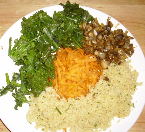 Plate with grated carrots, greens and couscous