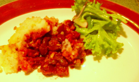 Bean and beetroot topped with mashed potato on a plate