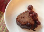 Slice of chocolate bean cake with unsweetcherries from a  jar