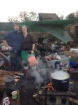 Makeshift field kitchen with two smiling cooks