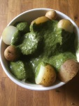 bowl of cooked new potatoes with green vinaigrette dressing 