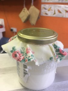 A jar of kefir with floral cloth cover
