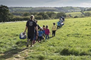 Farm school in crocodile formation on sunny fields of Huxhams Cross Farm