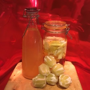 Peeled organic lemons assemble in front of last batch of homemade Limoncello 